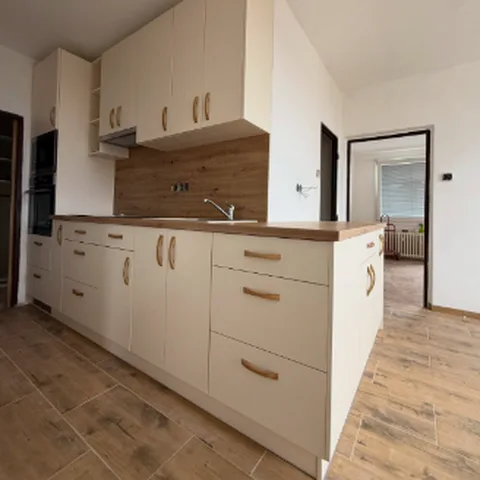 Kuchyňská linka v krémové barvě s dřevěnou deskou