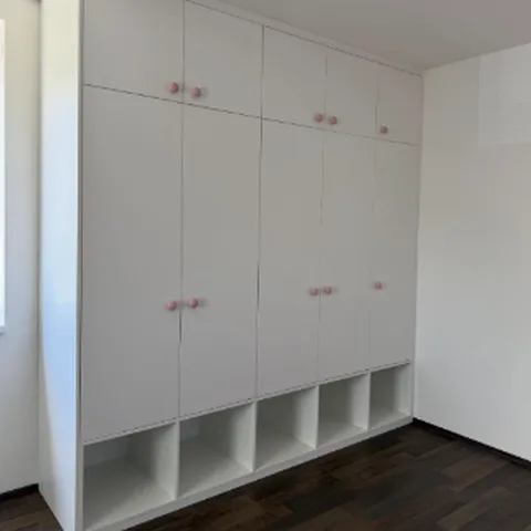 Bílá skříň do dětského pokoje s růžovými úchytkami